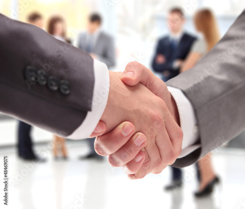 Photo: Closeup of business people shaking hands over a deal Closeup of business people shaking hands over a deal