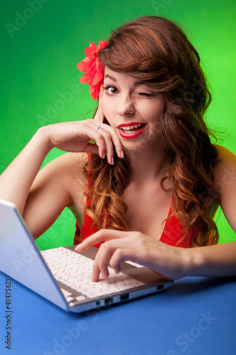 Photo: Portrait of smiling young woman working on a laptop Portrait of smiling young woman working on a laptop
