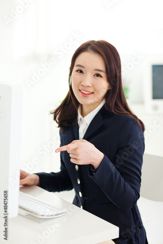 Photo: Happy Asian young woman using computer. Happy Asian young woman using computer.