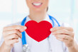 Photo: Female doctor with stethoscope holding red human heart at hospit Female doctor with stethoscope holding red human heart at hospit