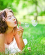 Photo: romantic young girl laying and inflating colorful soap bubbles romantic young girl laying and inflating colorful soap bubbles