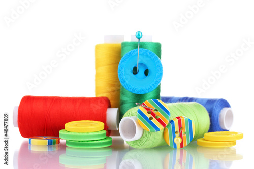 Photo: Many bobbin of thread with needle and buttons isolated on white Many bobbin of thread with needle and buttons isolated on white