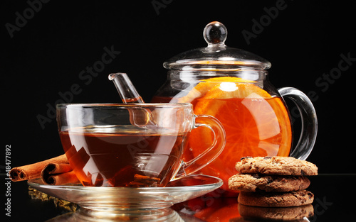 Photo: Glass teapot and cup with black fruit tea and cookies isolated Glass teapot and cup with black fruit tea and cookies isolated