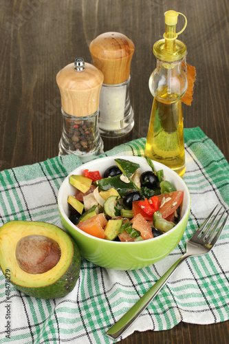 Photo: Tasty avocado salad in bowl surrounded by spices Tasty avocado salad in bowl surrounded by spices