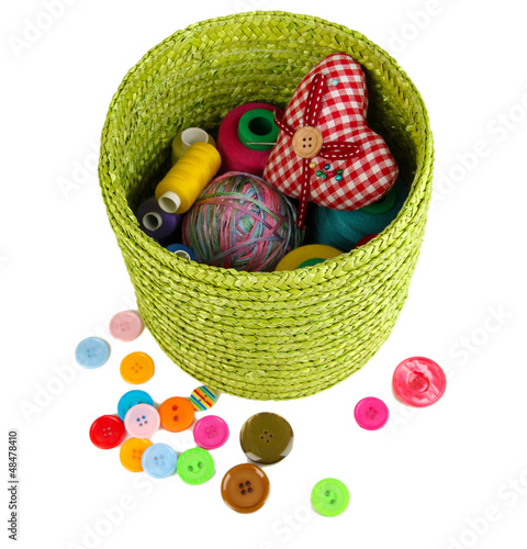 Photo: Green wicker basket with accessories for needlework isolated Green wicker basket with accessories for needlework isolated