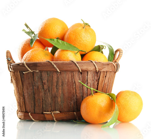Photo: Ripe sweet tangerine with leaves in basket, isolated on white Ripe sweet tangerine with leaves in basket, isolated on white