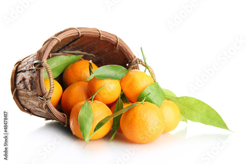 Photo: Ripe sweet tangerine with leaves in basket, isolated on white Ripe sweet tangerine with leaves in basket, isolated on white