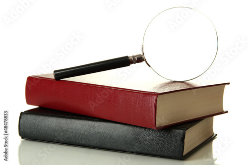 Photo: Magnifying glass and books isolated on white Magnifying glass and books isolated on white
