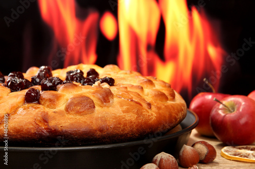 Photo: tasty homemade pie with jam, on wooden table on flame tasty homemade pie with jam, on wooden table on flame