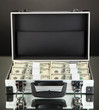 Suitcase with 100 dollar bills on black background