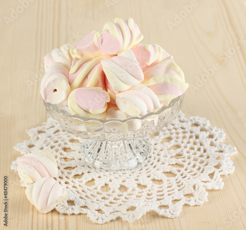 Photo: Gentle marshmallow in glass vase on wooden table close-up Gentle marshmallow in glass vase on wooden table close-up