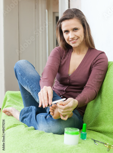 Photo: Beautiful girl cares for toenails Beautiful girl cares for toenails