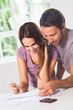 Smiling couple in front of invoices
