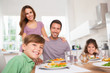Photo: Family looking at the camera at dinner time Family looking at the camera at dinner time
