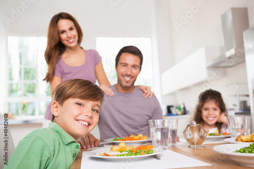 Photo: Family looking at the camera at dinner time Family looking at the camera at dinner time