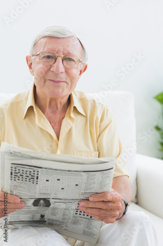 Photo: Smiling elderly man reading the news Smiling elderly man reading the news