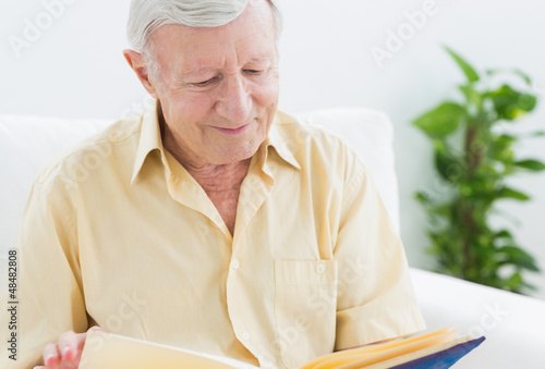 Photo: Elderly smiling man watching his album Elderly smiling man watching his album
