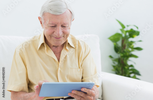 Photo: Elderly man using a digital tablet Elderly man using a digital tablet