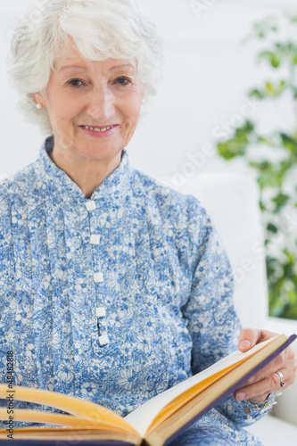Photo: Elderly smiling woman with photo album Elderly smiling woman with photo album