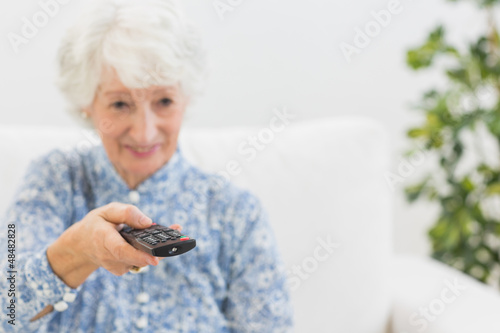 Photo: Elderly smiling woman using the remote Elderly smiling woman using the remote
