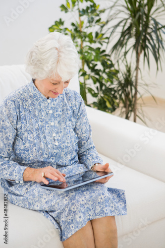 Photo: Elderly cheerful woman using a digital tablet Elderly cheerful woman using a digital tablet