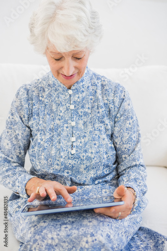 Photo: Elderly focused woman using a digital tablet Elderly focused woman using a digital tablet
