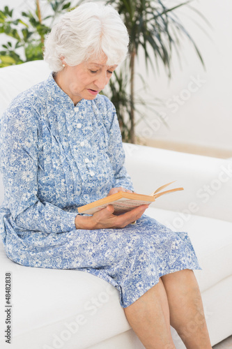 Photo: Elderly calm woman reading a old novel Elderly calm woman reading a old novel