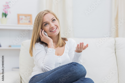 Photo: Casual happy woman using cellphone at home Casual happy woman using cellphone at home
