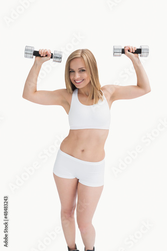 Photo: Portrait of young woman exercising with dumbbells Portrait of young woman exercising with dumbbells