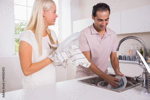 Photo: Happy couple washing dishes together Happy couple washing dishes together