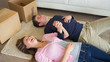 Laughing couple lying on floor with moving boxes
