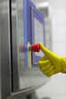hand in glove pressing   button at control panel in plant
