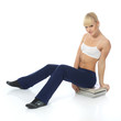 Athletic girl doing fitness exercises with a stack of magazines