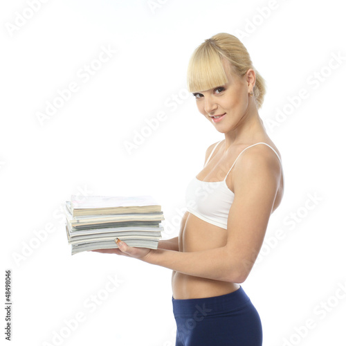 Photo: Athletic girl doing fitness exercises with a stack of magazines Athletic girl doing fitness exercises with a stack of magazines