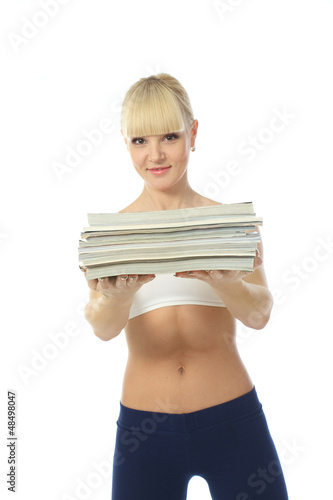 Photo: Athletic girl doing fitness exercises with a stack of magazines Athletic girl doing fitness exercises with a stack of magazines