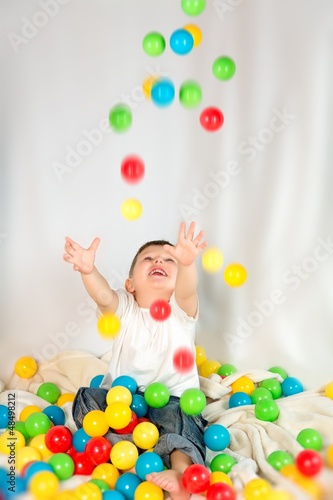 Photo: Cute boy playing colorful balls Cute boy playing colorful balls