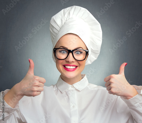 Photo: Happy woman cook chef showing thumbs up, close up Happy woman cook chef showing thumbs up, close up