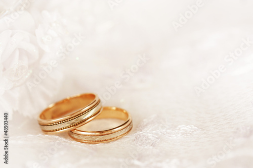 Photo: Two golden wedding rings with seamless flower decorations. Two golden wedding rings with seamless flower decorations.