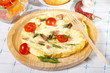 omelet with tomatoes on wooden plate