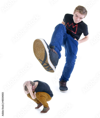 Photo: Großer Teenager tritt kleinen Teenager mit dem Fuß Großer Teenager tritt kleinen Teenager mit dem Fuß