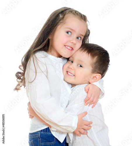 Photo: Little girl and boy hugging. Isolated on white Little girl and boy hugging. Isolated on white