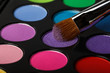 Close-up of colorful eyeshadow palette with brush 