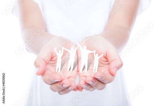 Photo: Hand with paper cut of family isolated on background Hand with paper cut of family isolated on background