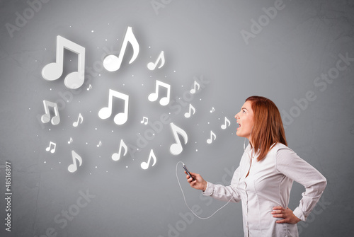 Photo: Pretty young woman singing and listening to music with musical n Pretty young woman singing and listening to music with musical n