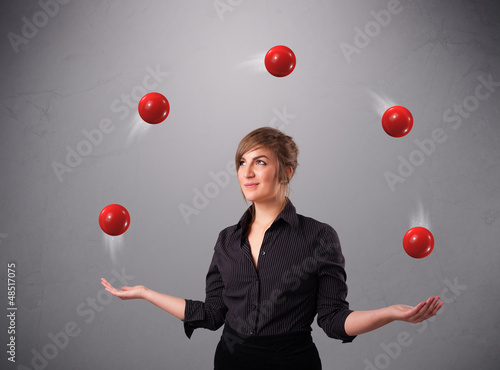 Photo: young girl standing and juggling with red balls young girl standing and juggling with red balls