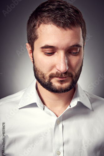 Photo: handsome man with beard looking down handsome man with beard looking down