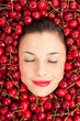 Photo: Young girl smiling portrait surrounded by cherries. Young girl smiling portrait surrounded by cherries.