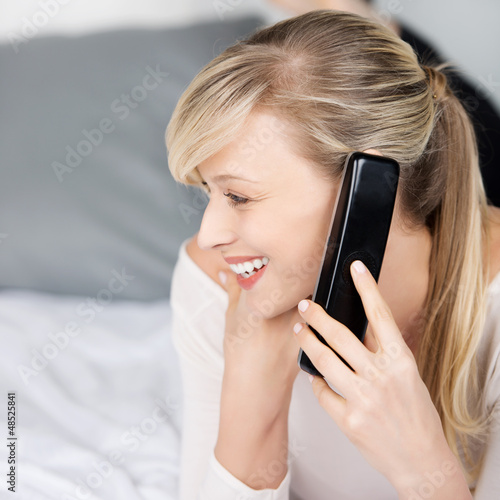 Photo: frau liegt auf dem bett und telefoniert frau liegt auf dem bett und telefoniert