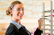 Junge Frau beim Optiker kauft Brille