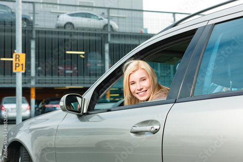 Photo: Woman back her car on a parking level Woman back her car on a parking level